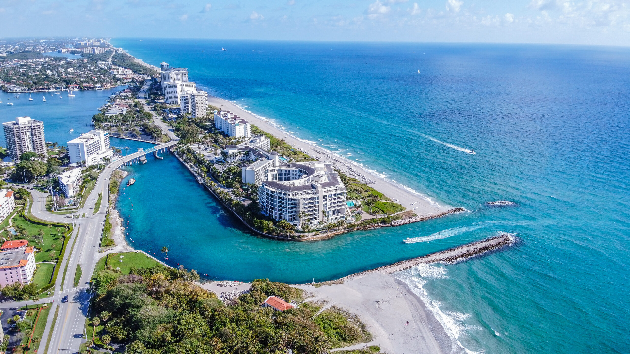 Boca Raton beach with clear blue waters and palm trees under a bright sunny sky