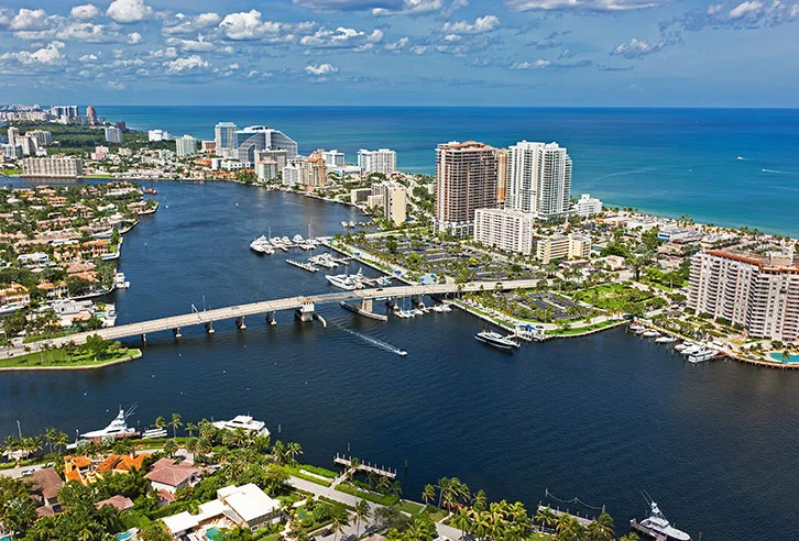 Fort Lauderdale beach with palm trees, white sand, and clear blue ocean waters.